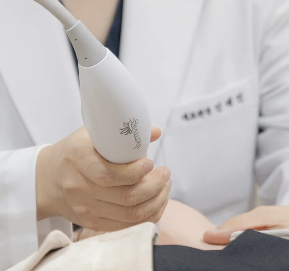 써마지 FLX 시술 장면 — 의료진이 팁을 얼굴에 대고 조사하는 모습